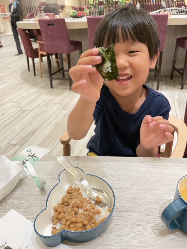 朝食で納豆巻きを食べる子供